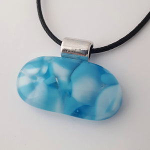 Blue and White wide oval glass fused pendant with silver coloured bail and black cord on white background
